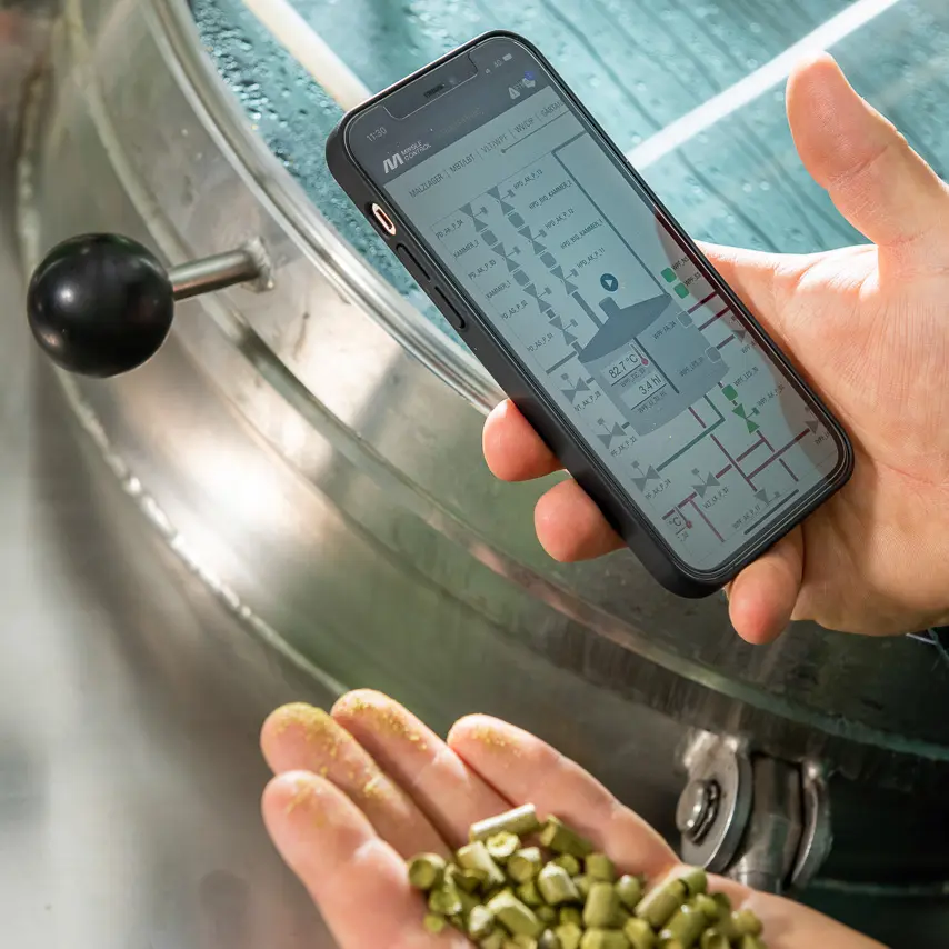 Smartphone mit MINGLECONTROL App und Hopfenpellets in der Hand
